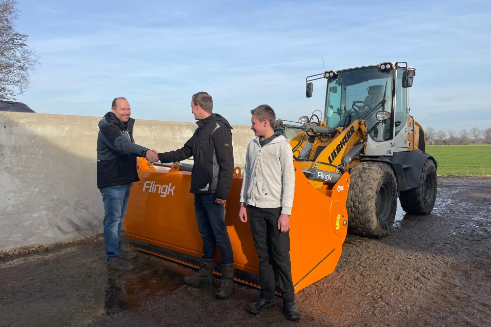 Niels van den Berselaar (links) van Flingk Machinebouw overhandigt de KHM 2400 kuilhapper aan Thuis en Willem van de Ven.